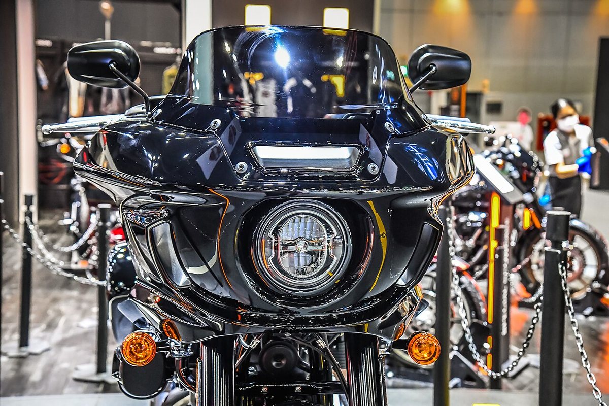 Front view of a black Harley-Davidson Low Rider ST: a frame-mounted fairing with a round LED headlight, a tall vent on each side of it and a short dark windscreen